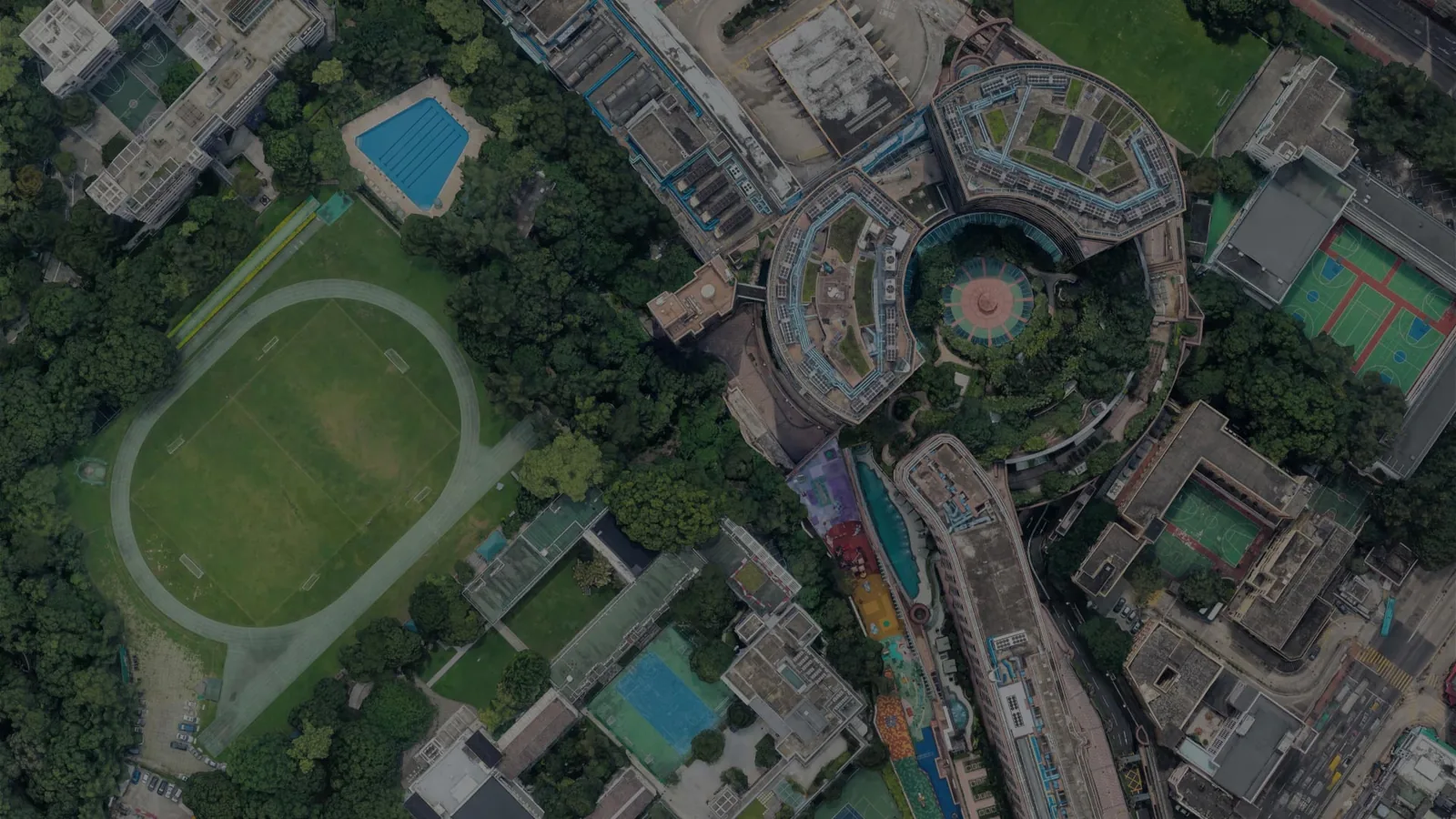 Vue aérienne en 3D d’un quartier urbain avec stade et bâtiments circulaires, telle que rendue par Google Earth Studio