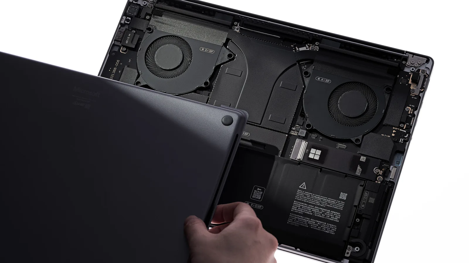 Surface Laptop Ultra ouvert, capot inférieur retiré, avec deux ventilateurs et le SSD amovible visibles